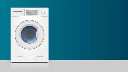 Witte wasmachine met blauwe trommel tegen een blauwe achtergrond. De vloer is grijs.