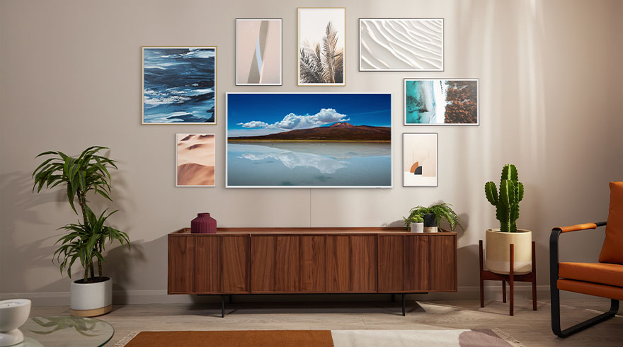 Woonkamer met houten kast, planten, cactus en kunst aan de muur. Een tv toont een landschapsfoto.