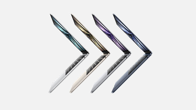 Four laptops, each a different color, are displayed in a row on a white background.
