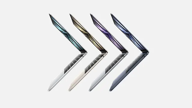 Four laptops, each a different color, are displayed in a row on a white background.