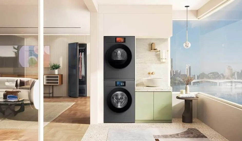 Stijlvolle wasruimte met grote ramen, gestapelde zwarte wasmachine en droger naast lichtgroene kasten en modern wastafelmeubel.