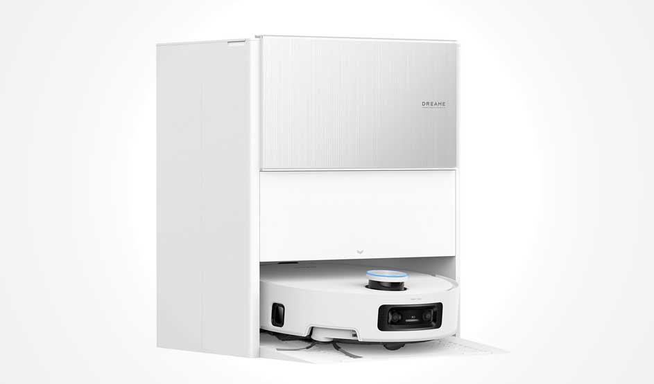 Een witte robotstofzuiger zit half in een groot wit basisstation; je ziet de camera, zijborstels en een ronde sensor met blauwe ring bovenop.