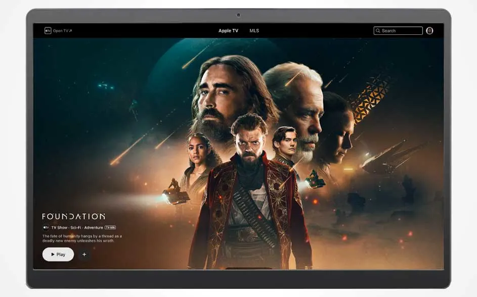 Op een tablet staat Apple TV met de sci-fi serie Foundation: meerdere gezichten, ruimteschepen en een Play-knop in een donkere ruimte.