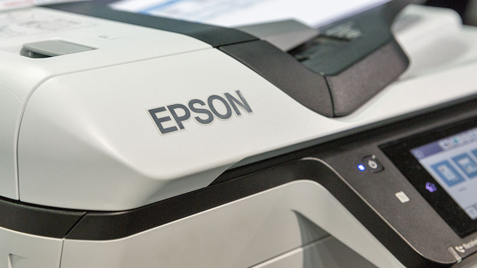 Een close-up van een witte Epson printer met zwart details en een bedieningspaneel met een blauw verlicht scherm.