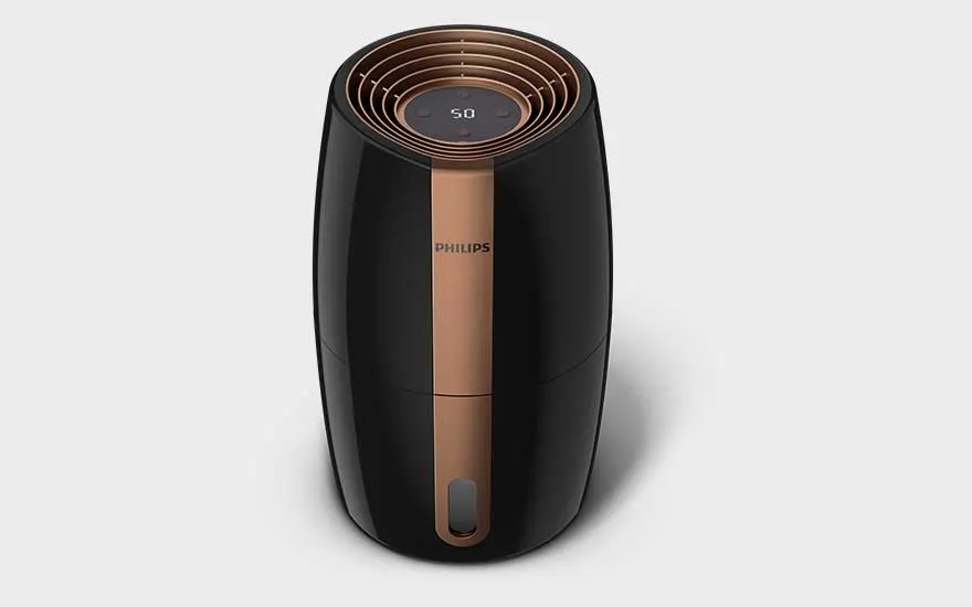 Een zwartkleurige Philips luchtbevochtiger met bronzen details en digitaal scherm, strak en modern, op een effen lichte achtergrond.
