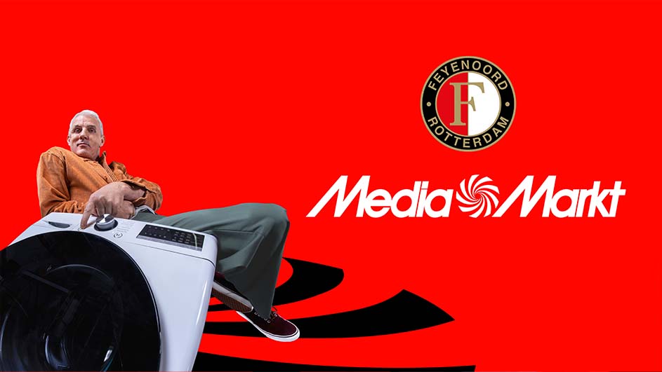 Man zit op wasmachine tegen rode achtergrond met Feyenoord logo en Media Markt tekst.