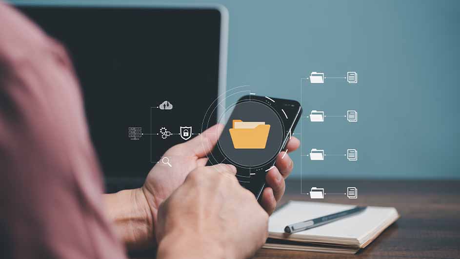 Een persoon houdt een telefoon vast met een map-icoon, voor een laptop. Er zijn data-overdracht iconen en een notitieboek met pen.