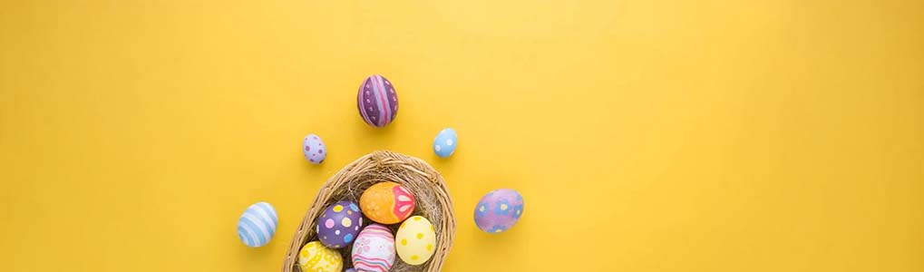 A yellow background features a bird's nest filled with colorful Easter eggs, some with polka dots and stripes.