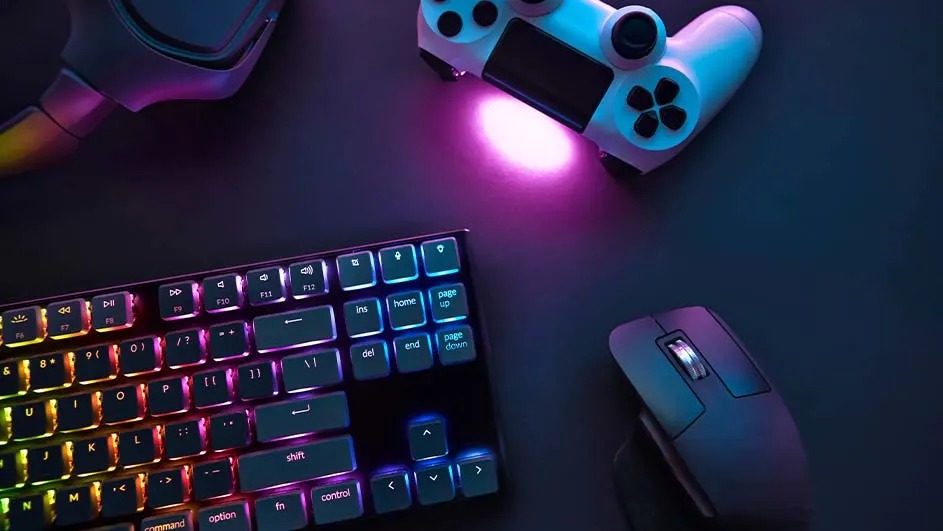 RGB-toetsenbord, witte controller met paars licht en een ergonomische muis op een donker bureau, klaar voor een gamingsessie.