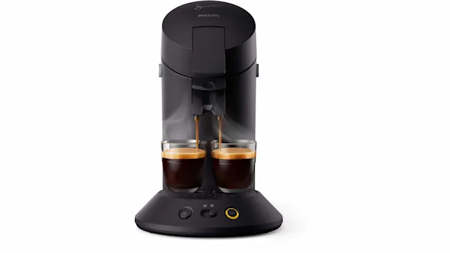 Zwarte Senseo koffiemachine vult twee glazen met koffie. De machine heeft knoppen op een ronde voet.