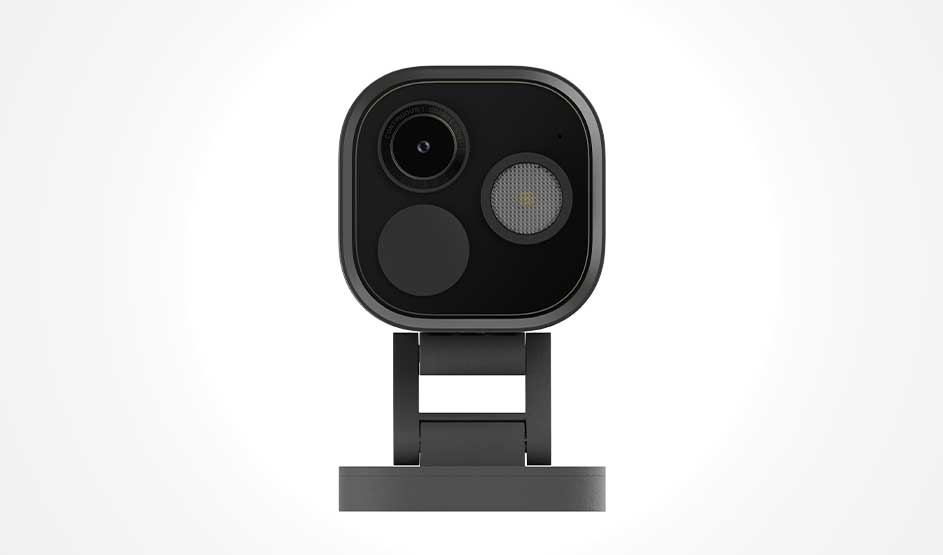 Een compacte zwarte slimme camera staat frontaal op een standaard, met lens en sensor zichtbaar tegen een lichte achtergrond.