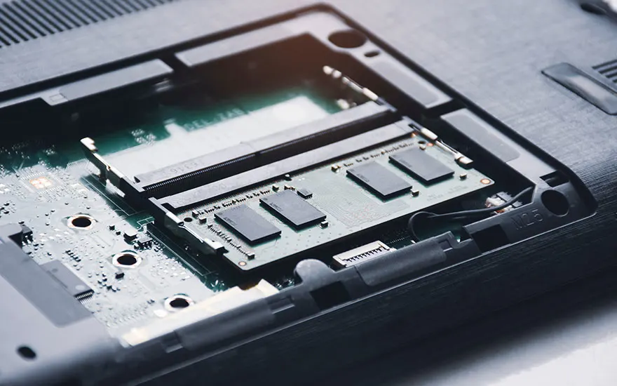 Geopende laptop toont interne componenten: RAM-geheugen slots, moederbord, circuitry, technische reparatie of upgrade view.