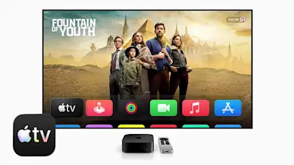 Op een grote tv verschijnt een avonturenserie met een gezin, onderaan icoontjes van Apple TV apps en streamingdiensten in felle kleuren.