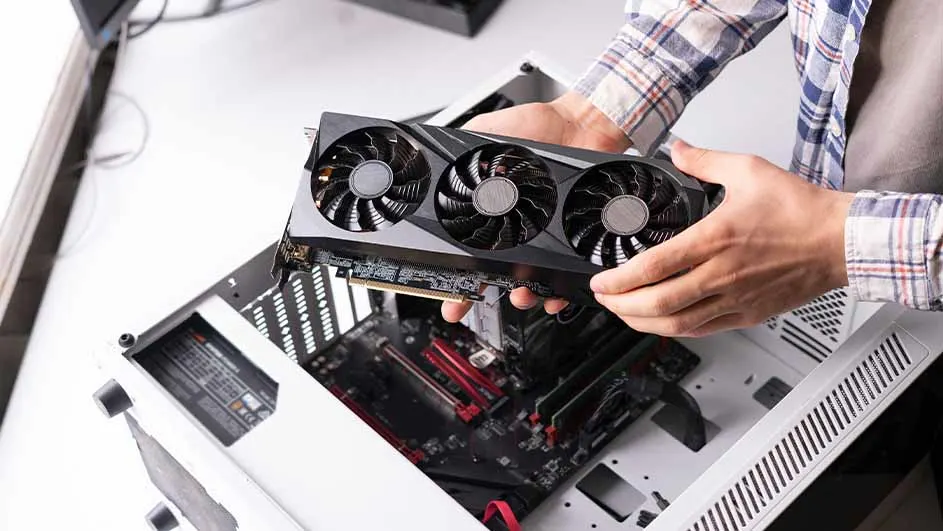 Een persoon houdt een grafische kaart met drie ventilatoren boven een open computerbehuizing.