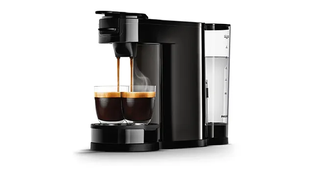 Een zwarte koffiemachine vult twee glazen met koffie, met een waterreservoir aan de zijkant.