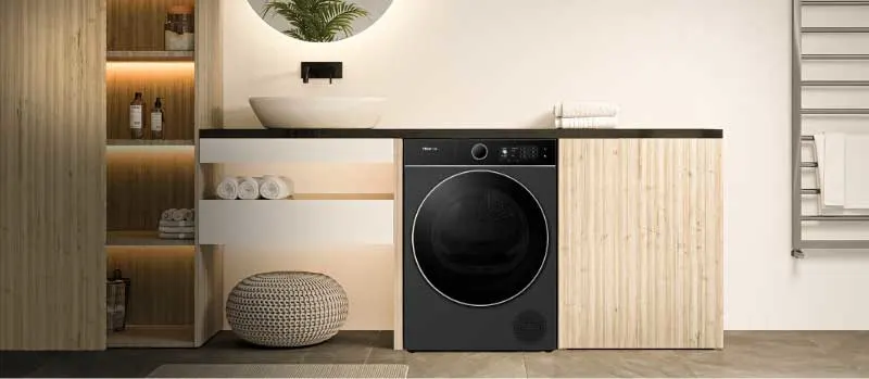 Een stijlvolle badkamer met zwarte wasmachine, houten kasten, ronde spiegel, waskom, open planken en zachte verlichting in warme tinten.