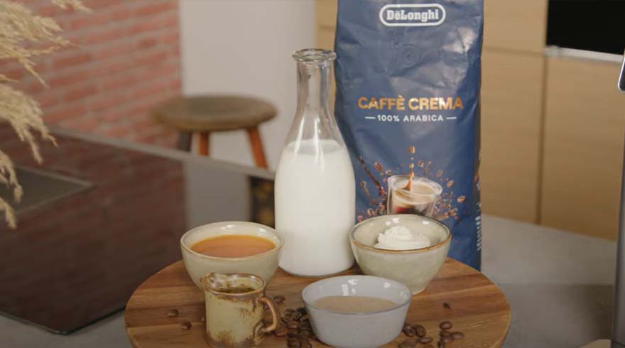 Een tafel met een fles melk, kopjes koffie, een zak koffiebonen en losse koffiebonen.