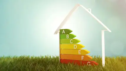 Energie-efficiëntielabel A tot G met een wit huis silhouet op groen gras tegen een blauwe achtergrond.