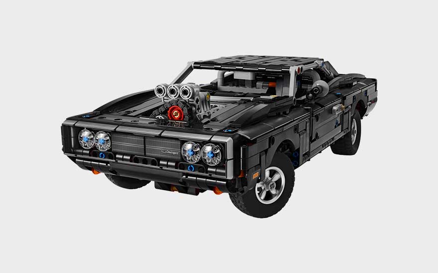 Zwarte LEGO muscle car met grote motor op de motorkap, vier koplampen, robuuste wielen en stoere klassieke uitstraling.