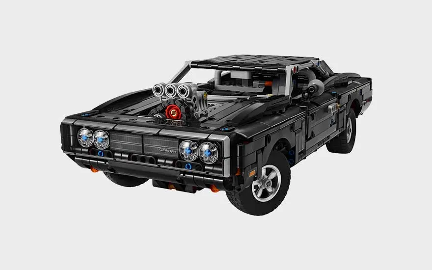 Zwarte LEGO muscle car met grote motor op de motorkap, vier koplampen, robuuste wielen en stoere klassieke uitstraling.