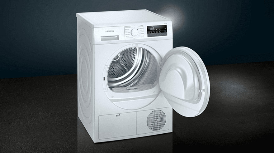 Een witte wasdroger met een open deur staat op een donkere vloer voor een donkere achtergrond.