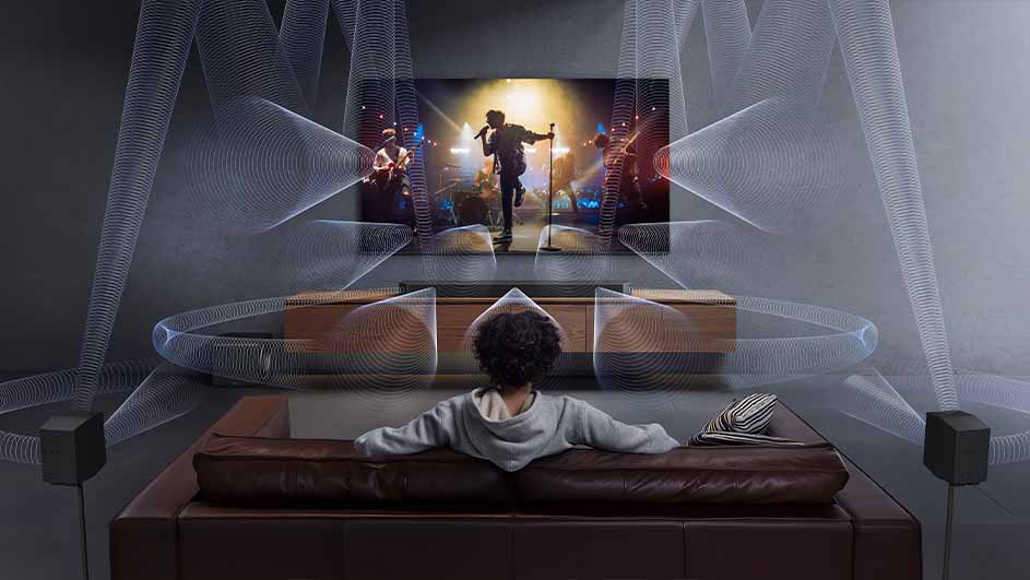 Een kind kijkt tv op een bruine bank, met luidsprekers aan weerszijden. De tv toont een live band, met audio golven.