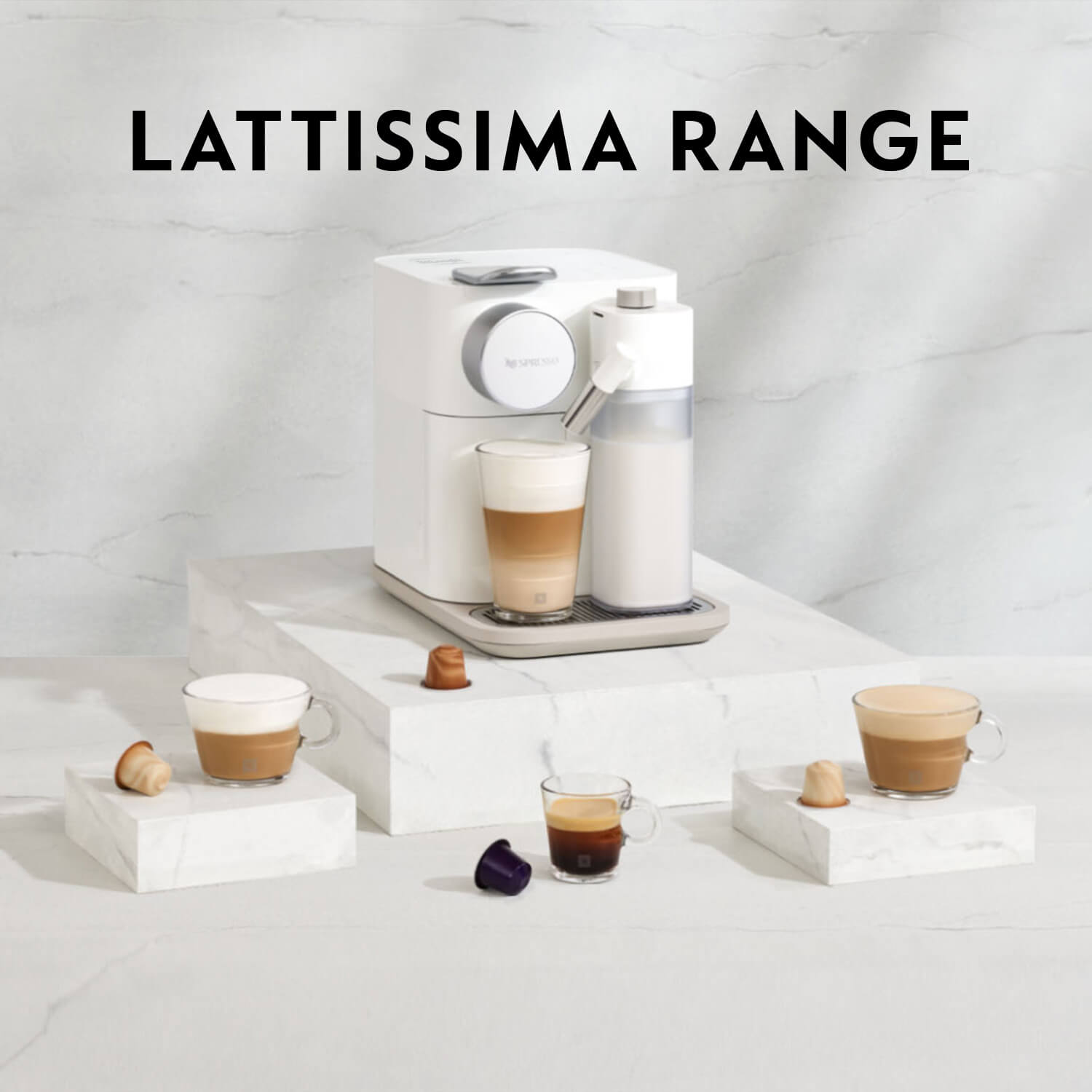 Witte koffiemachine met melkreservoir en diverse glazen koffie op witte blokken met capsules. "Lattissima Range" in zwarte letters.
