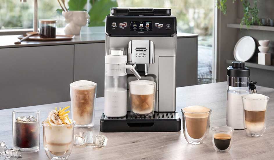 Op het aanrecht staat een De’Longhi koffiemachine, omringd door zes glazen met verschillende koffiespecialiteiten, melk en ijsklontjes.