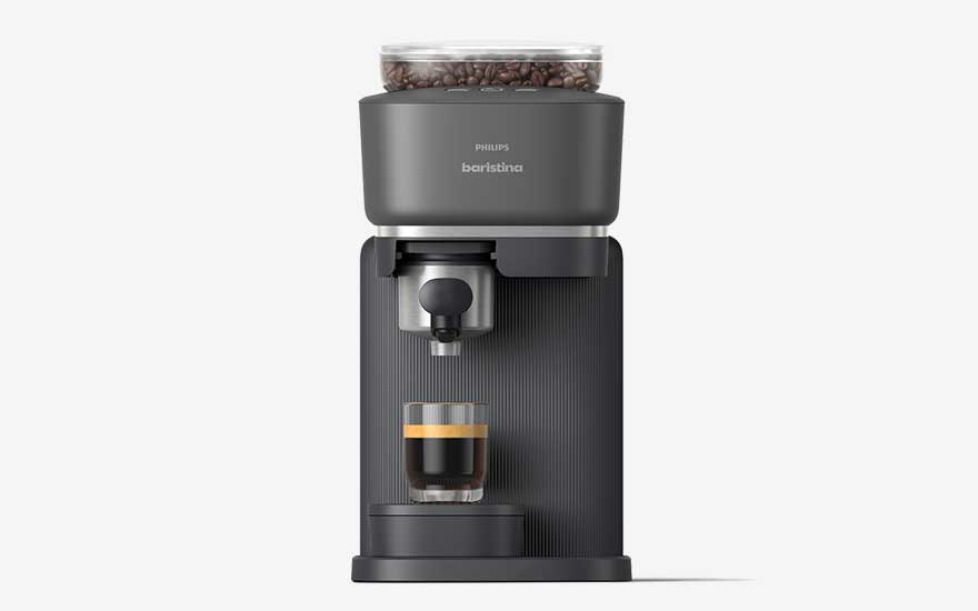 A grey Philips Barista coffee machine with a bean hopper on top and a small glass of espresso with crema underneath.