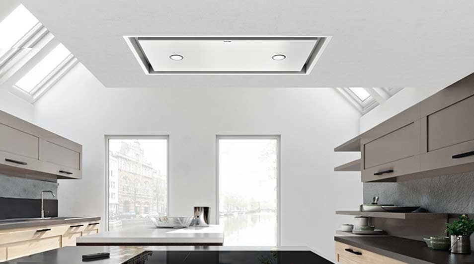 Bright modern kitchen with skylights, tall windows, sleek grey cabinets and a glossy black island.