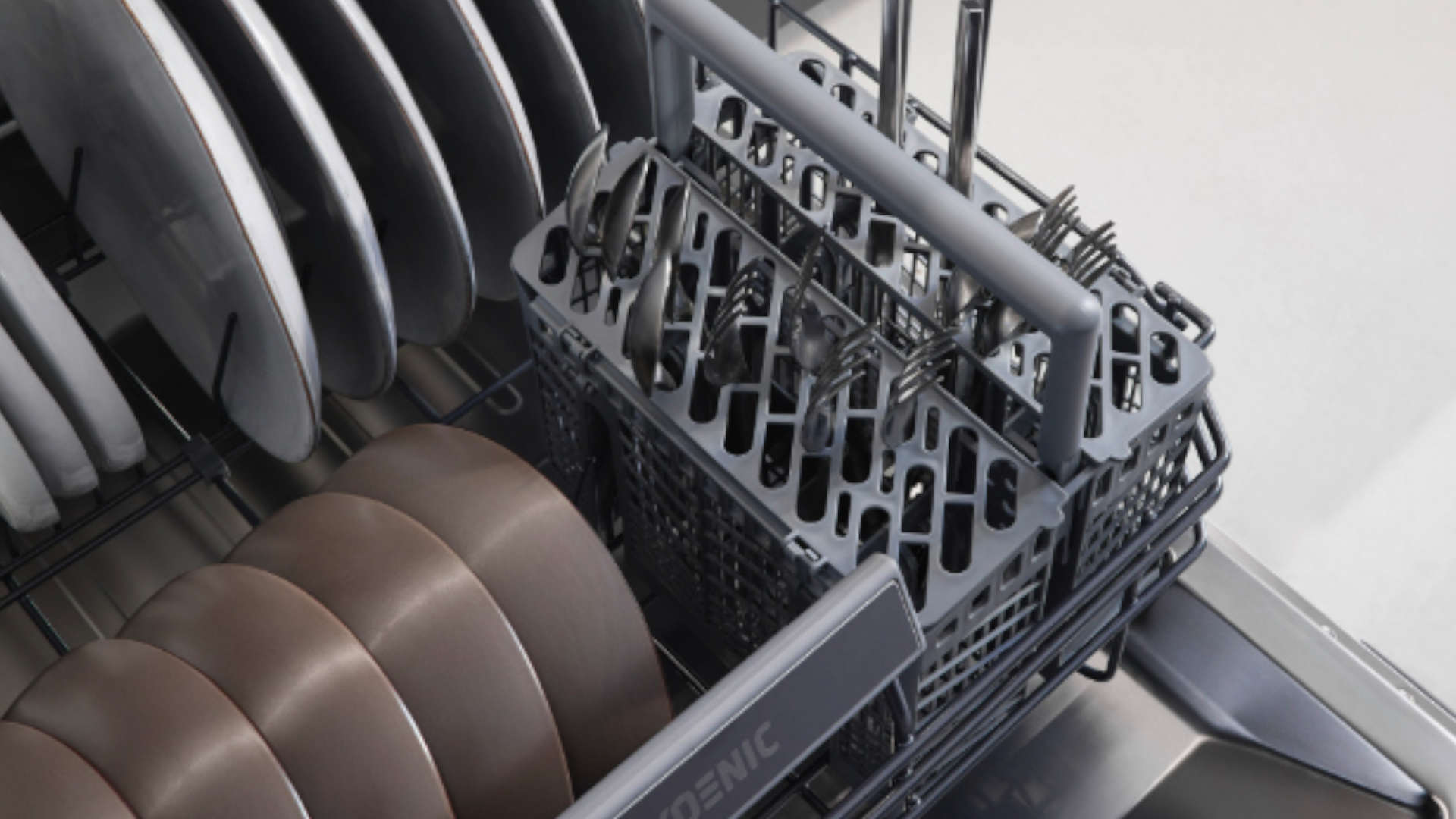 Bestekmand en vaat in de onderkorf van de KOENIC vaatwasser KDW 6051-1 C FI, van bovenaf genomen.