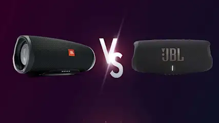 Twee zwarte JBL-luidsprekers staan tegenover elkaar met een wit "Vs"-symbool op een paarse achtergrond.