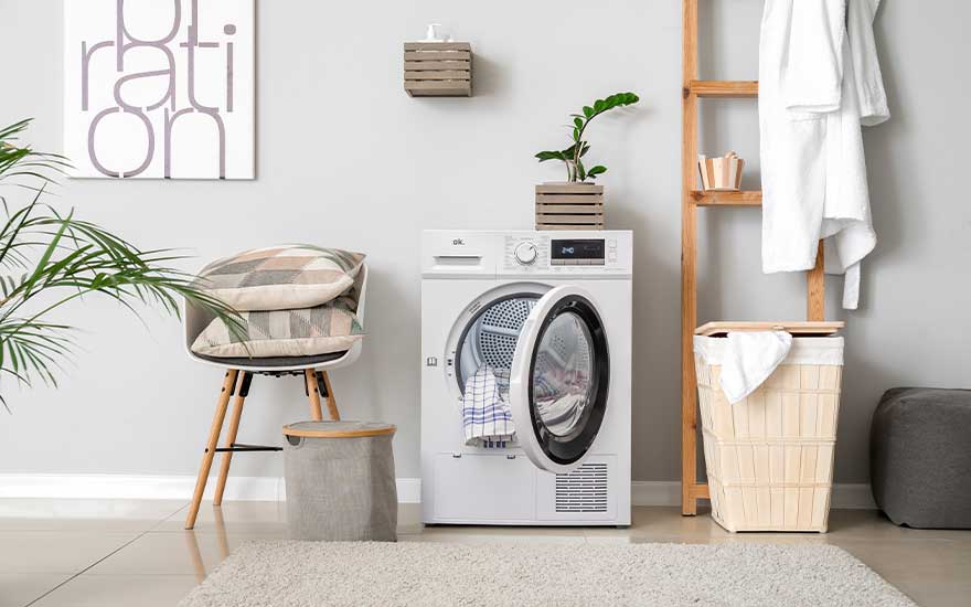 Scandinavian laundry room with white washing machine, wooden ladder and baskets. Minimalist décor with natural materials throughout.