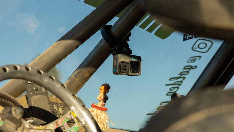 Een camera is aan een buis bevestigd in een voertuig met een stuur en een hula meisje tegen een blauwe lucht achtergrond.