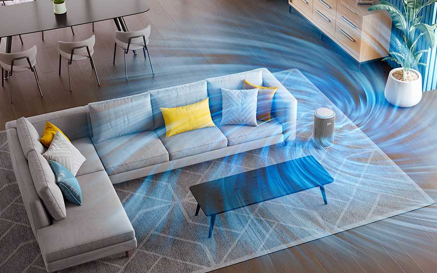 Bovenaanzicht van een ruime woonkamer waar een luchtreiniger krachtige luchtstromen rond een hoekbank en salontafel door de hele kamer blaast.