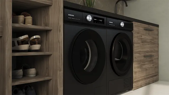 Een foto van een zwarte wasmachine en droger naast een houten schoenenkast en kast.