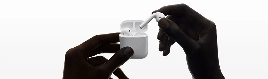 Two hands hold white wireless earbuds and a charging case against a white background.
