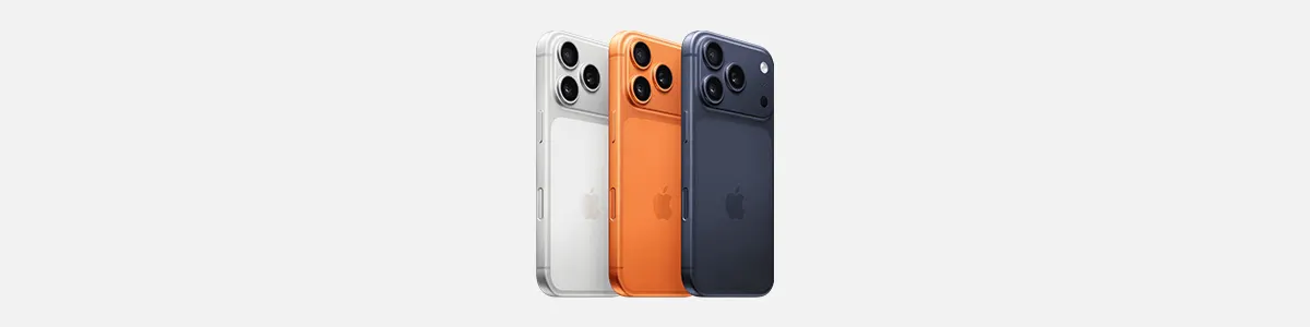 Drie kleuren iPhone 17 Pro Max-toestellen naast elkaar in zilver, oranje en donkerblauw, met afgeronde hoeken en meerdere cameralenzen achterop, op een lichte achtergrond.