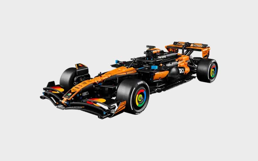 Oranje en zwarte LEGO Formule 1-racewagen met brede banden, lage neus, achtervleugel en kleurrijke details op de wielen.