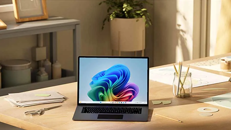 Een laptop met een kleurrijk patroon op het scherm staat op een houten bureau met kantoorartikelen en planten.