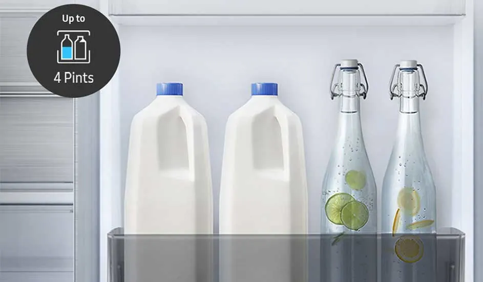 In de deur van de koelkast staan twee melkflessen met blauwe dop en twee glazen flessen water met schijfjes limoen en citroen.