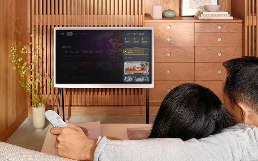 Koppel kijkt televisie met Google TV afstandsbediening in de hand.
