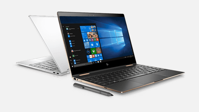 Twee laptops; een zwart en open met Windows, een witte en dicht. Een styluspen ligt voor de zwarte laptop.