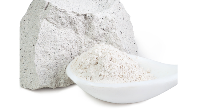 Grof, wit rotsblok naast witte poeder in een witte lepel tegen een witte achtergrond.