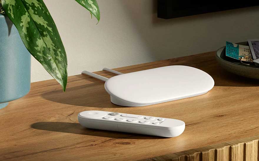 Chromecast apparaat en afstandsbediening op een houten tafel.