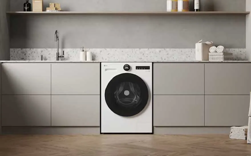 Moderne lichte wasruimte met ingebouwde witte wasmachine, lange kasten, spoelbak, planken en netjes gevouwen handdoeken.