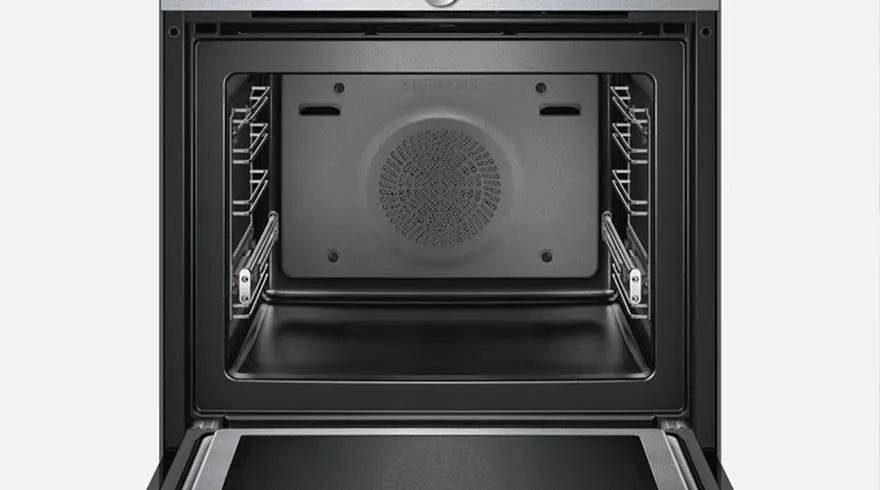 Een open, lege, zwarte oven met metalen rekken aan de zijkanten tegen een witte achtergrond.