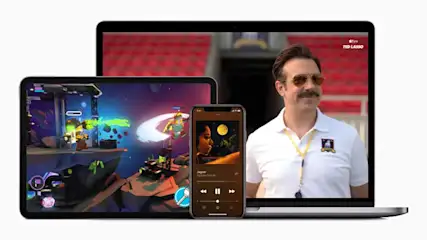 Laptop toont 'Ted Lasso', tablet een game, en telefoon een muziekapp, geplaatst op een witte achtergrond.