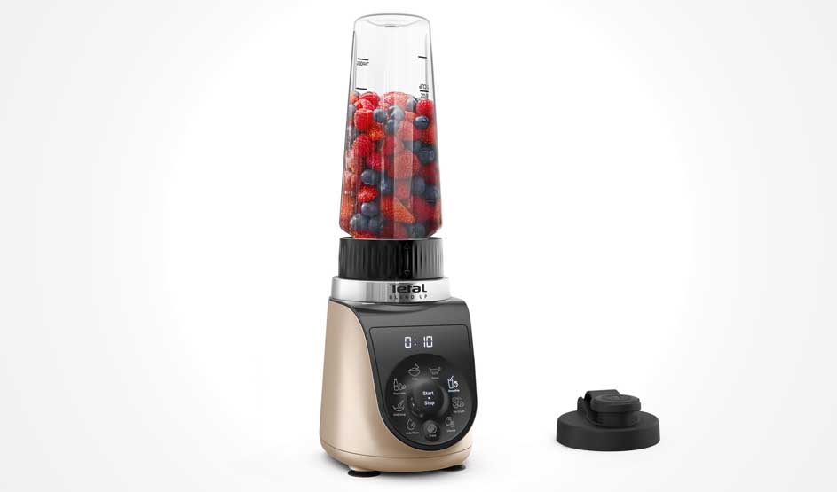 Een Tefal-blender op wit: omgekeerde beker vol aardbeien en bosbessen, digitale timer en knoppen op de basis; extra deksel ernaast.