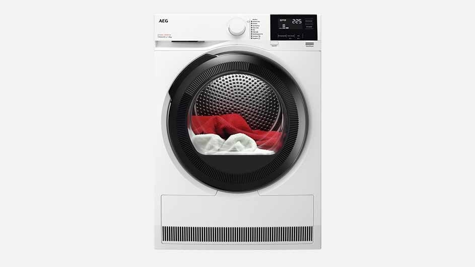 A white AEG tumble dryer with a round black door and digital display is shown, filled with red and white laundry, ready for drying.